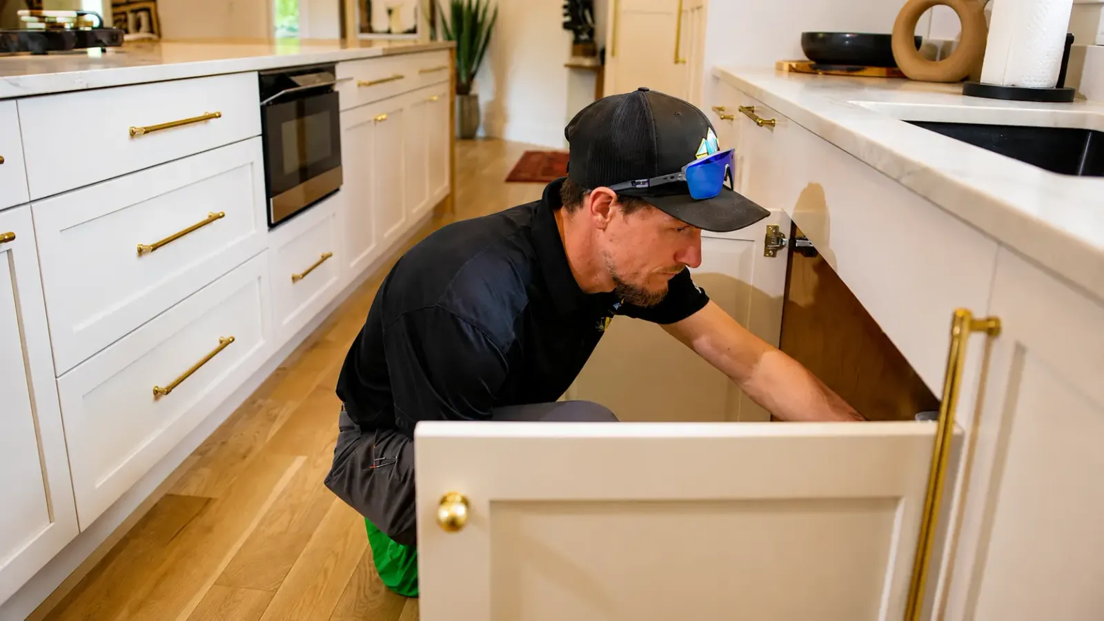 Element plumber checking under a kitchen sink in Flagstaff